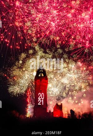 Stirling, Scotland, UK. 1 January 2021. Pictured: Hogmanay pyrotechnic spectacular closes off 2020 and brings in 2021 with a bang as colourful explosions burst lighting up the new year night sky 600feet above the Wallace Monument in Stirling. Due to the coronavirus (COVID19) pandemic the show will be live streamed on TV and online since Scotland is in phase 4 lockdown. Edinburgh based events company, 21CC Events Ltd, pyrotechnic specialists have spent the last few days setting up the show including powerful projection lights for the monuments facade. Credit: Colin Fisher/Alamy Live News. Stock Photo