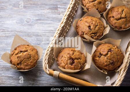 Homemade buckwheat muffins with dried fruits in a basket on a wooden table, top view, free space, selective focus Stock Photo