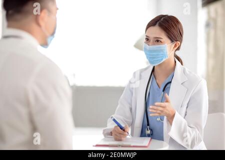 doctor explaining diagnosis to her male patient Stock Photo
