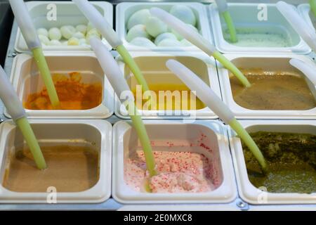 Various sauces in containers with spoons in a self-service cafe in a shopping mall Stock Photo