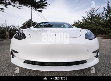 Moss Beach USA - January 1, 2021: Pearl white electric Tesla Model 3 dual motor performance AWD car with 20 inch Uberturbine wheels near San Francisco Stock Photo