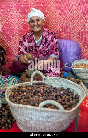 A lady cracks chestnuts in a co-operative factory near Imlil in Morocco. The co-op was established to give Moroccan women  work opportunities. Stock Photo