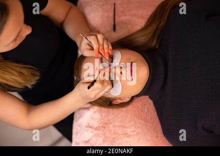 Woman Going Through Eyelash Extension Procedure in Beauty Clinic Stock Photo