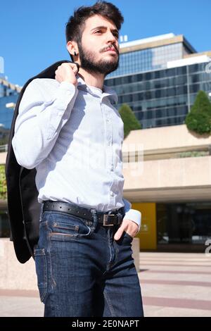 Young business man portrait with buildings in the background. Businessman in a urban street of a city. Stock Photo