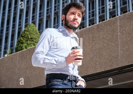 Young business man with a coffee cup in his hand. Businessman in a urban street of a city. Stock Photo