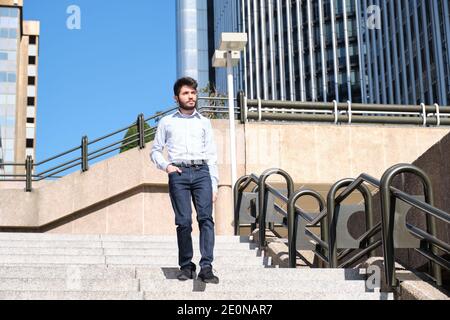 Young business man walking down stairs with a hand in his pocket. Businessman in a urban street of a city. Stock Photo