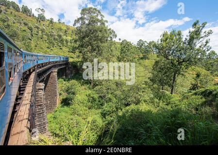 The Ella to Kandy Diesel train locomotive winds through tea plantations near Nuwara Eliya, Sri Lanka. Stock Photo