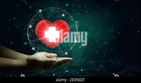 Hand holding red heart with white cross symbol. World map background. Health care, Health insurance, Charity, and Medicine concept. Copy space. Stock Photo