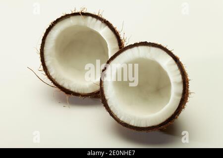 Coconut broken in two parts isolated shot in studio on white background. Stock Photo