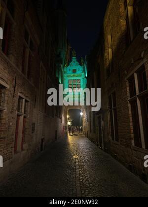 Blinde-Ezelstraat blind donkey street arch bridge illuminated dark narrow cobblestone alley at night in Bruges West Flanders Flemish region Belgium Stock Photo