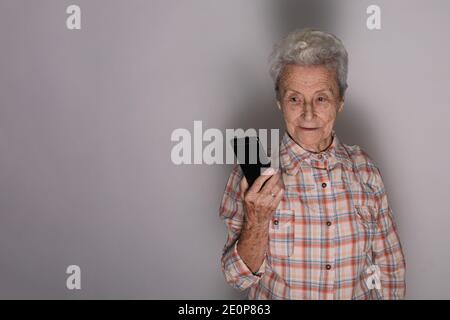 Old woman looking at a smartphone. Stock Photo