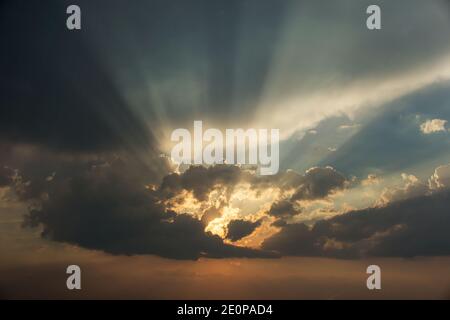 natural dramatic sunset with sunbeams peeping out from behind the clouds Stock Photo