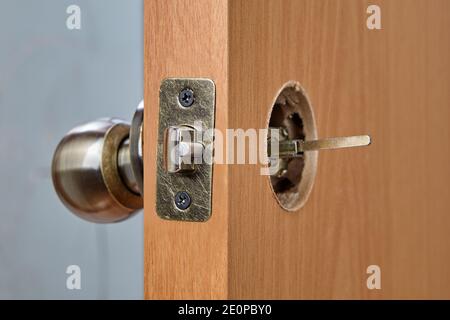 The spindle of the doorknob mechanism is visible from the back of the wooden interior door when the lock is installed. Stock Photo