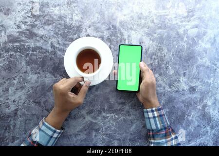 flat composition of young man hand using smart phone and drinking coffee  Stock Photo