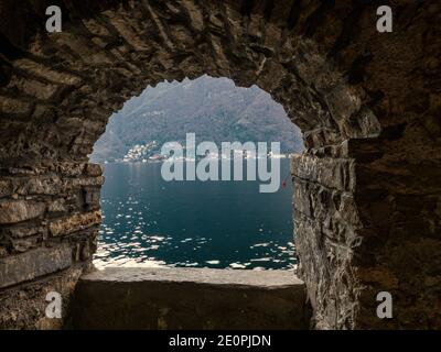 Landscape of Como lake seen from a window of an ancient stone building.Lombardy, Italian Lakes, Italy. Stock Photo