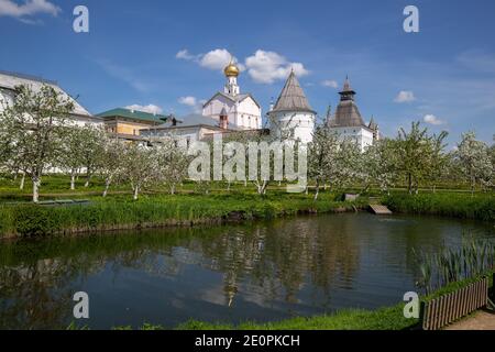 Spring Metropolitan Garden with blossoming apple trees in Rostov Kremlin against background of monastery towers and church. Rostov the Great, Yaroslav Stock Photo