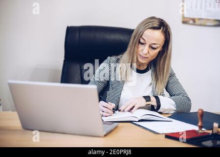 A notary, a woman lawyer works in her office, records appointments. Stock Photo