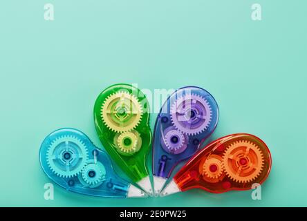 Stationery correction tapes are Multicolored on a blue background. Free space. The view from the top. Blue, green, yellow, lilac Stock Photo