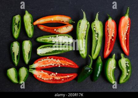 Ripe homegrown red and green jalapeno chilli peppers exposed to reveal seeds and membranes. UK Stock Photo