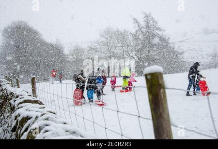 Downham, Clitheroe, Lancashire, UK. 2nd Jan, 2021. A snow storm on Pendle Hill near Downham, Clitheroe, Lancashire surprised people sledging and walkers . Credit: John Eveson/Alamy Live News Stock Photo