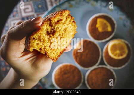 Girl holding fresh cupcake in her hand. Close-up texture of the dough Stock Photo