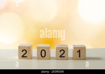 Happy new year 2021 creative ideas cubes on wooden tables on yellow blur background. Stock Photo