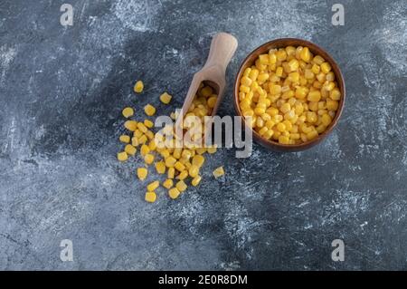 Spoon and bowl of sweet corns on marble background Stock Photo