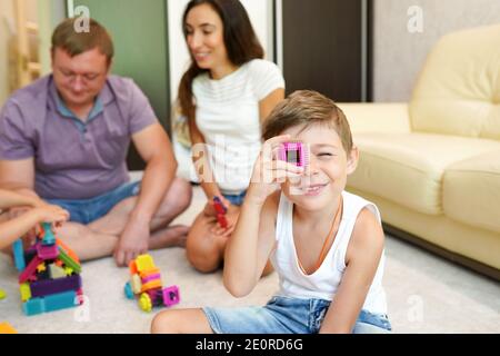 Family playing with toy blocks at home on the floor Stock Photo