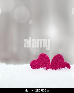 Two red wooden Hearts in the snow on grey background. Valentines day concept. Stock Photo