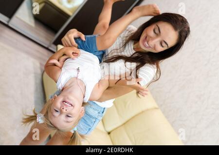 Funny woman and kid playing in home Stock Photo