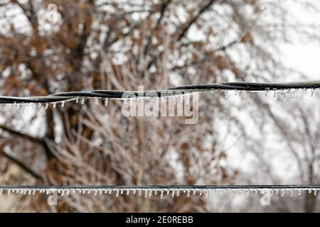 Closeup of ice on power line from freezing rain. Concept of winter storm and power outage. Stock Photo