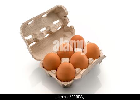 Egg box with eggs, six chicken eggs in cardboard egg tray made from recycled paper isolated on white background Stock Photo