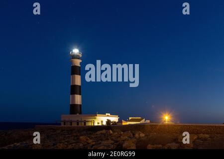 The Cap d'Artrutx Lighthouse or Artrutx Lighthouse (Catalan: Far d'Artrutx) is an active 19th century lighthouse located on the low-lying headland of Stock Photo