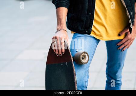 Close up of diversity young teenager concept with young teenager holding skate board and have black nails colored - casual and trendy people outdoor w Stock Photo