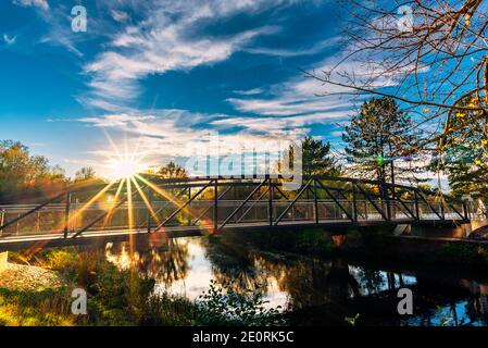 footbridge over a river in sunset Stock Photo