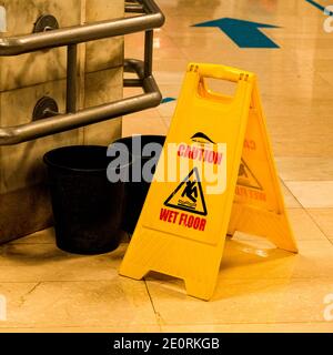 London UK, January 02 2021, Two Black Plastic Buckets And A Caution Wet Floor Sign In A UK Shopping Centre Stock Photo