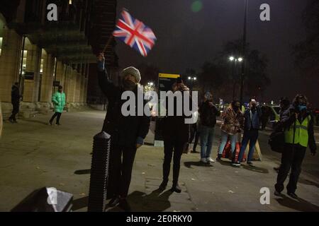 A woman has brought a Union Flag to celebrate the UK finally leaving the European Union as the Brexit transition period ends at 11pm on New Year's Eve Stock Photo