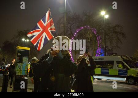 A woman has brought a Union Flag to celebrate the UK finally leaving the European Union as the Brexit transition period ends at 11pm on New Year's Eve Stock Photo