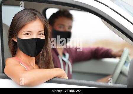 Driver and Asian passenger woman wearing face masks happy portrait in car driving buying new car or instructor with driver for test at driving school Stock Photo