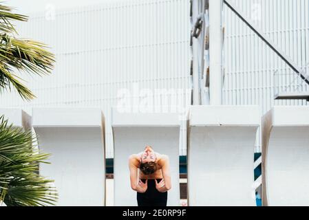 Portrait of a young man practicing yoga doing a concentrated Ustrasana, Camel Pose or back bending pose. Stock Photo