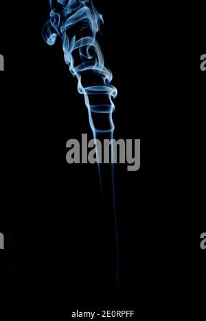 blue gray smoke with lots of swirling on black background Stock Photo