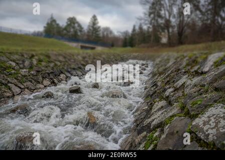 Man made creek with stones and blurry water Stock Photo