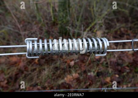 Spring. Metal spring on an electric fence. Stock Photo
