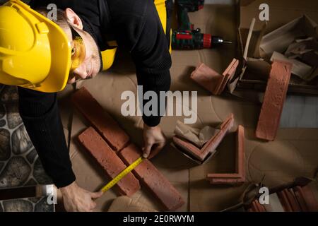 While measuring with a pull-out measure, a manual worker found time to smile and enjoy the job he is doing. Stock Photo