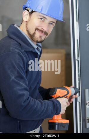 contractor using cordless screwdriver on door frame Stock Photo