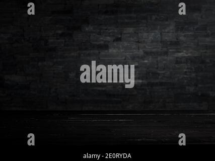 Old black table in front of dark stone wall Stock Photo