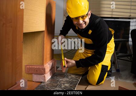 While measuring with a pull-out measure, a manual worker found time to smile and enjoy the job he is doing. Stock Photo