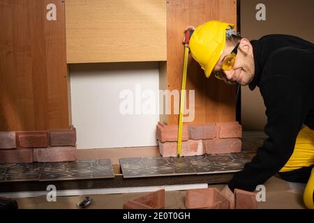 While measuring with a pull-out measure, a manual worker found time to smile and enjoy the job he is doing. Stock Photo