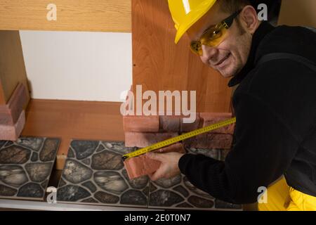 While measuring with a pull-out measure, a manual worker found time to smile and enjoy the job he is doing. Stock Photo