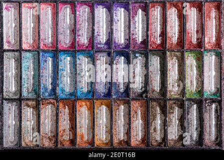 Flat lay view of broken empty eye shadow makeup palette container with lot colors. Abstract background concept. Stock Photo